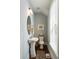 Powder room featuring pedestal sink, oval mirror, window with blinds, and decorative accents on wood floor at 34 Dereef Ct, Charleston, SC 29403