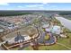 Aerial view of the community highlighting new construction, a lake, pool, clubhouse, and green spaces at 410 Eliston St, Summerville, SC 29486