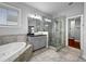 Modern bathroom with a glass shower, soaking tub, and tiled floor at 410 Eliston St, Summerville, SC 29486