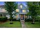 Charming two-story blue home with a pink door, surrounded by mature trees and lush landscaping at 410 Eliston St, Summerville, SC 29486