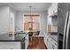 A kitchen with a sink island and breakfast area that includes wood floors and white cabinets at 410 Eliston St, Summerville, SC 29486