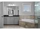Bright bathroom featuring large mirror, sleek sink, soaking tub, and chrome faucet at 410 Eliston St, Summerville, SC 29486