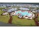An aerial view captures the expansive community pool with a waterslide, palm trees, and lush landscaping at 410 Eliston St, Summerville, SC 29486