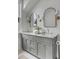 A stunning bathroom features a double vanity with marble countertop, elegant sconces, and modern arched mirrors at 507 Mccants Dr, Mount Pleasant, SC 29464