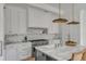 Elegant white kitchen with marble countertops, stainless steel appliances, and stylish pendant lighting above the island at 507 Mccants Dr, Mount Pleasant, SC 29464