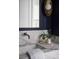 Dark blue powder room featuring marble countertop, bronze fixtures, and a modern mirror and sconce at 507 Mccants Dr, Mount Pleasant, SC 29464