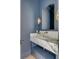 Blue powder room featuring marble countertop, bronze fixtures, and a modern mirror and sconces at 507 Mccants Dr, Mount Pleasant, SC 29464