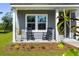 Inviting front porch with rocking chairs, manicured flower beds, and charming curb appeal at 5115 Cranesbill Way, Johns Island, SC 29455