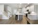 Modern open-concept kitchen with white cabinets, island with bar stools, and stainless steel appliances at 5115 Cranesbill Way, Johns Island, SC 29455