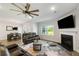 Cozy living room with fireplace, comfortable leather seating, and a ceiling fan at 5115 Cranesbill Way, Johns Island, SC 29455