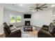 Bright living room with hardwood floors, fireplace, and modern ceiling fan at 5115 Cranesbill Way, Johns Island, SC 29455