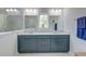 Bright bathroom featuring marble floors and shower, and double sink vanity with custom blue cabinets at 5525 Alpine Dr, Summerville, SC 29483