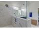 Bright bathroom featuring marble floors and shower, and double sink vanity with custom blue cabinets at 5525 Alpine Dr, Summerville, SC 29483