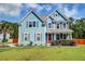 Inviting two-story home with a red front door, manicured bushes and lawn at 5525 Alpine Dr, Summerville, SC 29483