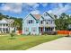 Charming two-story blue house with lush landscaping and a spacious front yard at 5525 Alpine Dr, Summerville, SC 29483