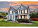 Charming two-story home with blue siding and a manicured front yard set against a colorful sunset sky at 5525 Alpine Dr, Summerville, SC 29483