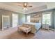 Bright main bedroom with a tray ceiling, bench seat, and ensuite bathroom entrance at 5525 Alpine Dr, Summerville, SC 29483