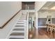 Elegant staircase with dark wood floors and white railings, leading to a spacious hallway at 5525 Alpine Dr, Summerville, SC 29483