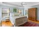 Bright bedroom features a ceiling fan, two windows, hardwood floors, and neutral decor at 601 King Haven Ln, Johns Island, SC 29455