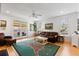Sunlit living room with a leather sofa, vintage decor, and access to a patio at 601 King Haven Ln, Johns Island, SC 29455