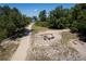 Drone eye view of a recreation area with fire pit, Adirondack chairs, benches, and sandy walking path at 601 King Haven Ln, Johns Island, SC 29455