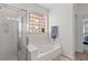 Bathroom with a soaking tub, a glass block window, and a separate glass-enclosed shower at 6242 Fieldstone Cir, Charleston, SC 29414