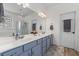 Bright bathroom with a double sink vanity, a large mirror, and a glass block window at 6242 Fieldstone Cir, Charleston, SC 29414