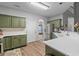 Well-lit kitchen featuring wooden floors, stainless steel appliances, and green cabinets at 6242 Fieldstone Cir, Charleston, SC 29414