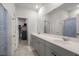 Bright bathroom featuring a double vanity with gray cabinets, a large mirror, and a view into the walk-in closet at 630 Jancus St, Charleston, SC 29414