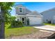 Charming gray home featuring green grass, lush foliage, and a pristine two-car garage at 630 Jancus St, Charleston, SC 29414