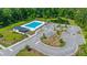 Aerial view of community pool, pool house, parking, landscaping, and surrounding woods at 630 Jancus St, Charleston, SC 29414
