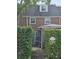 Brick house featuring dormer windows, a wrought iron gate, and lush green hedges surrounding the property at 70 Legare St, Charleston, SC 29401