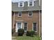 Traditional brick home featuring a white front door, symmetrically balanced windows, and manicured bushes at 70 Legare St, Charleston, SC 29401