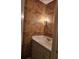 Cozy powder room features patterned wallpaper, vanity with sink, and a sconce at 70 Legare St, Charleston, SC 29401