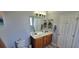 Bright bathroom featuring double sinks, wood cabinets and a large mirror at 7019 Lanier St, Hanahan, SC 29410