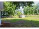 Expansive backyard featuring a storage shed and a mix of grassy and wooded areas with a fence at 7774 Ginger Ln, North Charleston, SC 29420