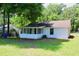 Charming home with a screened porch and a well-maintained lawn surrounded by lush trees at 7774 Ginger Ln, North Charleston, SC 29420