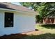 Side view of a well-maintained white brick house with black-trimmed windows and a brown roof at 7774 Ginger Ln, North Charleston, SC 29420