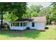 Charming home with a screened porch and a well-maintained lawn surrounded by lush trees at 7774 Ginger Ln, North Charleston, SC 29420