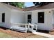 Inviting front entrance with charming porch railing and freshly painted white brick facade at 7774 Ginger Ln, North Charleston, SC 29420