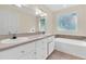 Bright bathroom featuring a double vanity, garden tub, and large window offering natural light at 7869 High Maple Cir, North Charleston, SC 29418
