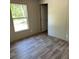 A light and airy bedroom with gray wood-look floors and a sunny window with views of trees at 852 Lawyer Ln, Cross, SC 29436