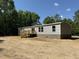 Side view of a manufactured home with grey siding, brick skirting, a small porch and wood deck at 852 Lawyer Ln, Cross, SC 29436