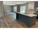Modern kitchen with gray island, white cabinets, stainless steel appliances, and views into the living area at 852 Lawyer Ln, Cross, SC 29436