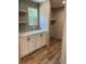 Functional laundry room with white cabinets, gray backsplash, and vinyl flooring at 852 Lawyer Ln, Cross, SC 29436