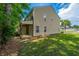 Side exterior view of the home with a patio and green lawn at 9098 Maple Grove Dr, Summerville, SC 29485
