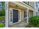 Inviting covered porch with black front door and manicured landscaping, creating great curb appeal at 9098 Maple Grove Dr, Summerville, SC 29485