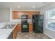 Kitchen with wooden cabinets and appliances, including a black refrigerator and stove at 9098 Maple Grove Dr, Summerville, SC 29485