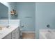 Light blue bathroom featuring bathtub, toilet, and double vanity with decorative shelves at 1026 Briar Rose Ln, Ladson, SC 29456