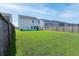Lush green backyard offers a simple design, a house, and wooden fences creating a private outdoor setting at 112 Whisper Dr, Summerville, SC 29485